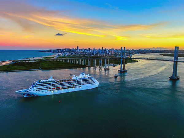 Navio de cruzeiro com a Ponte Newton Navarro ao fundo